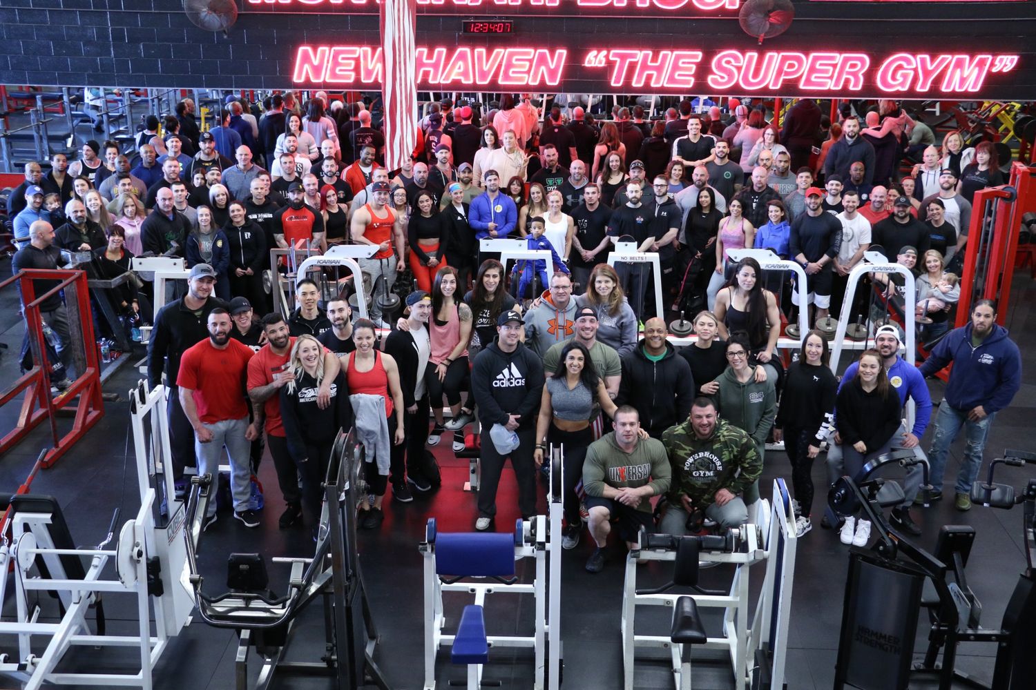 A large group of people gathered for a Tuttle Nutrition client event inside a gym.
